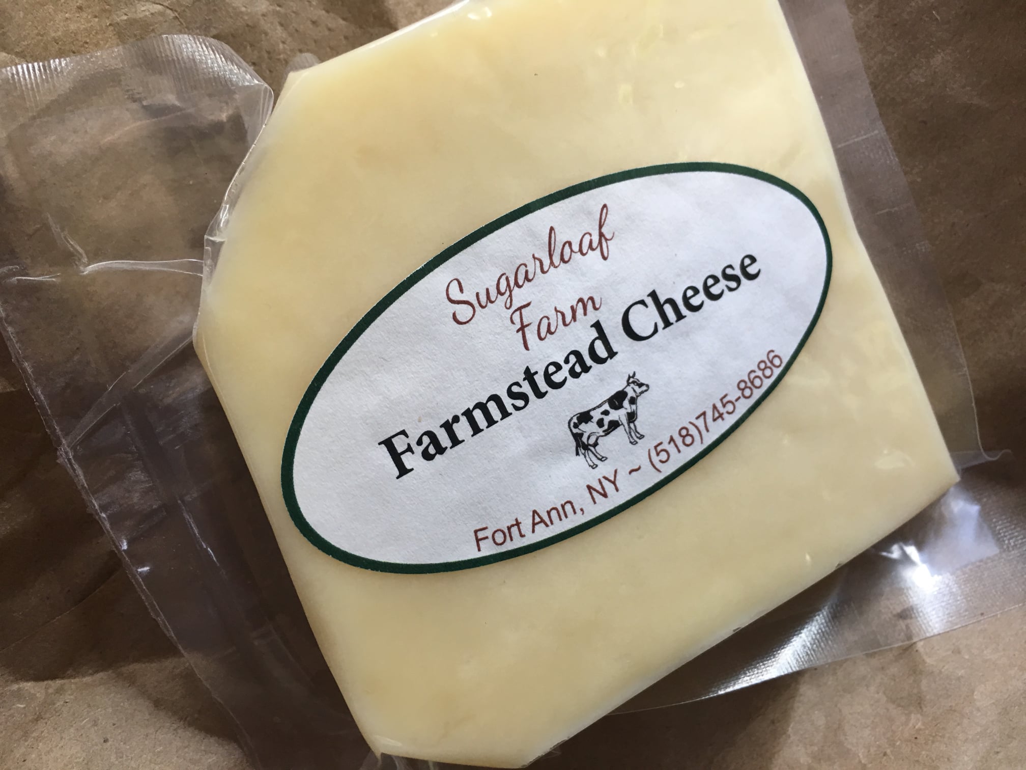Printed  oval label for cheese includes cow logo and cheese name