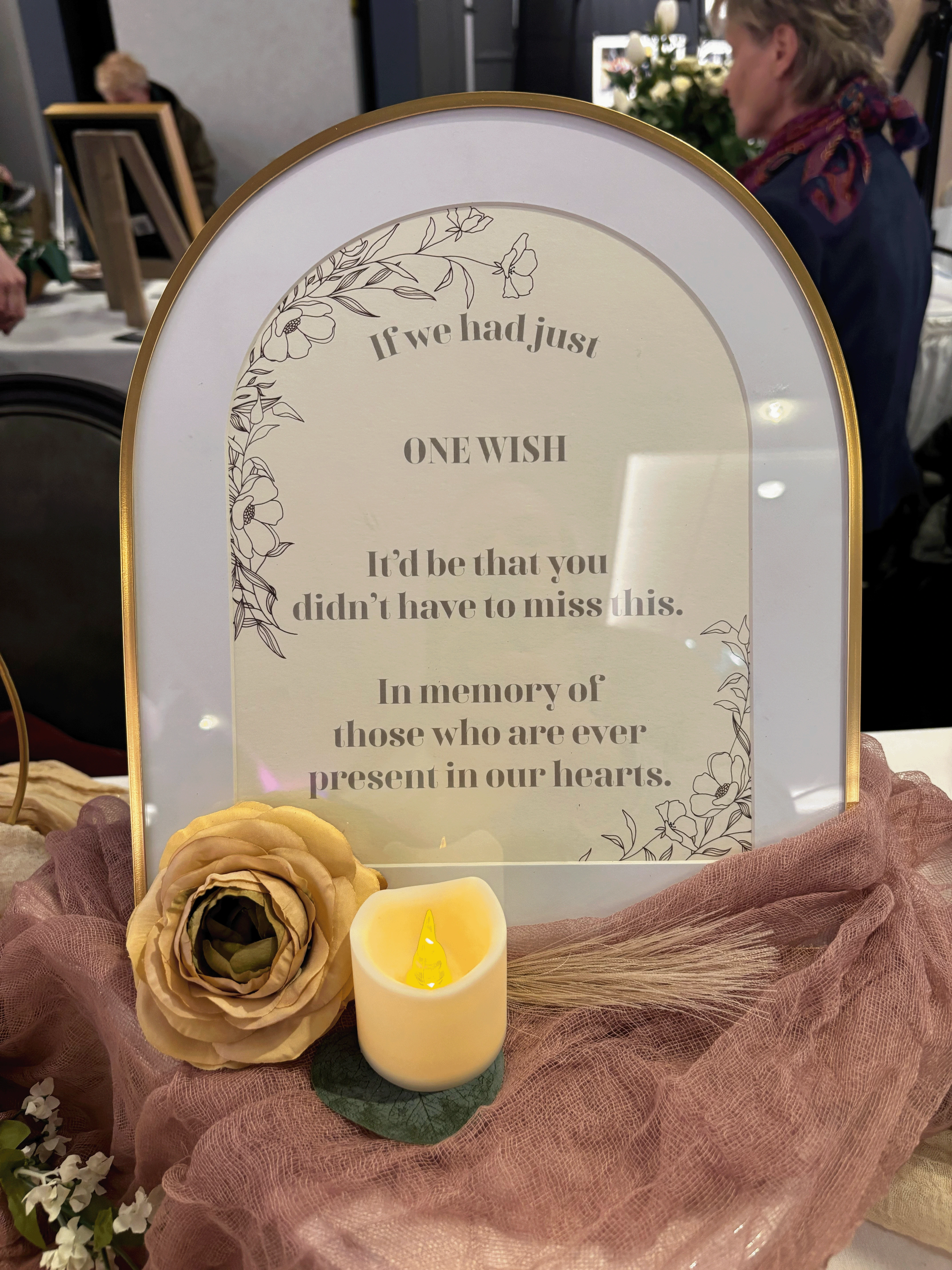 Memory sign in an arc frame remembering those that could not be at the wedding due to loss.